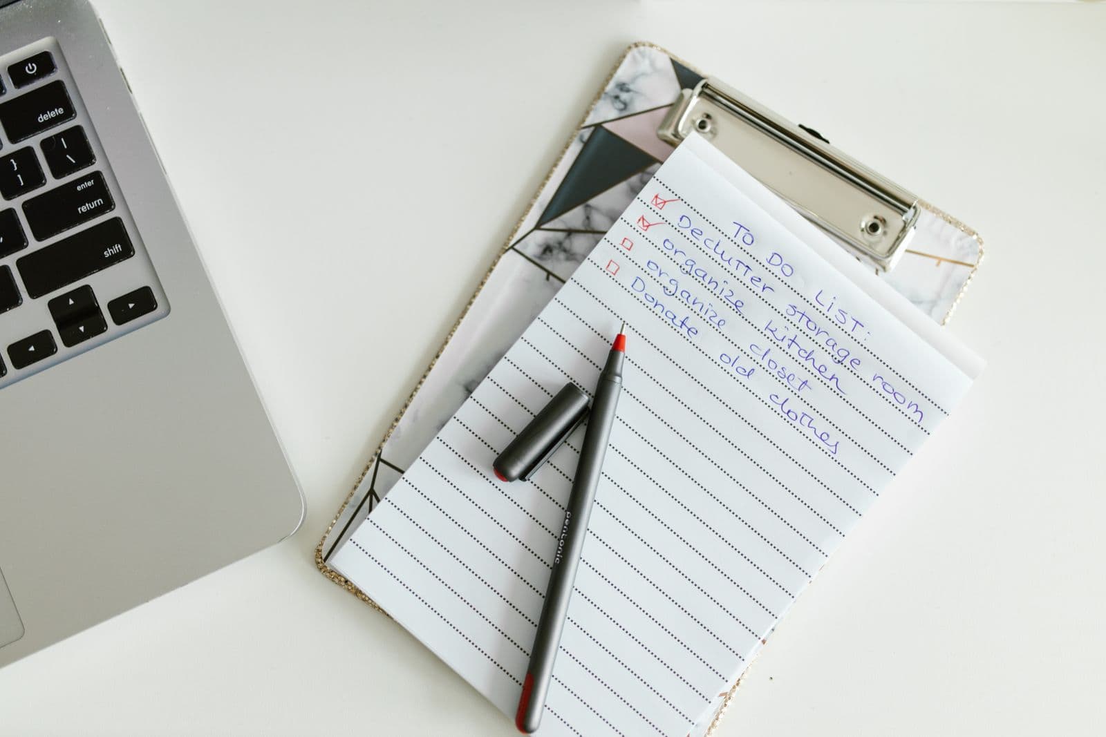 To-do list on a clipboard next to a laptop