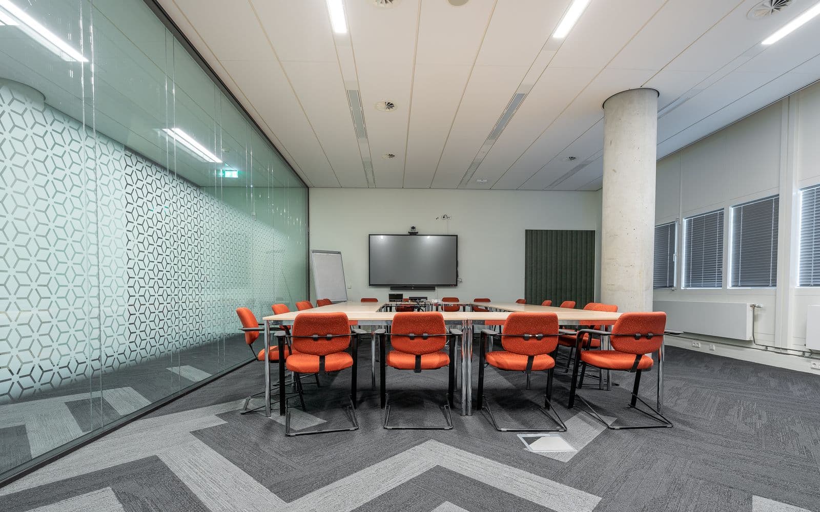 Large meeting room with a long table, many chairs and a glass wall
