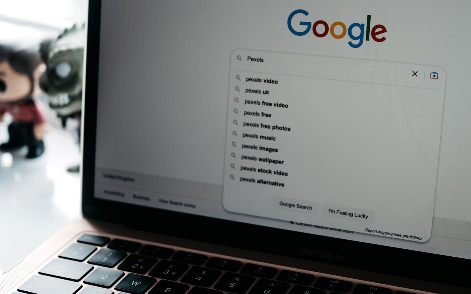 Laptop auf einem Schreibtisch, im Browser ist eine Suchseite mit aufgeklappten Vorschlägen geöffnet