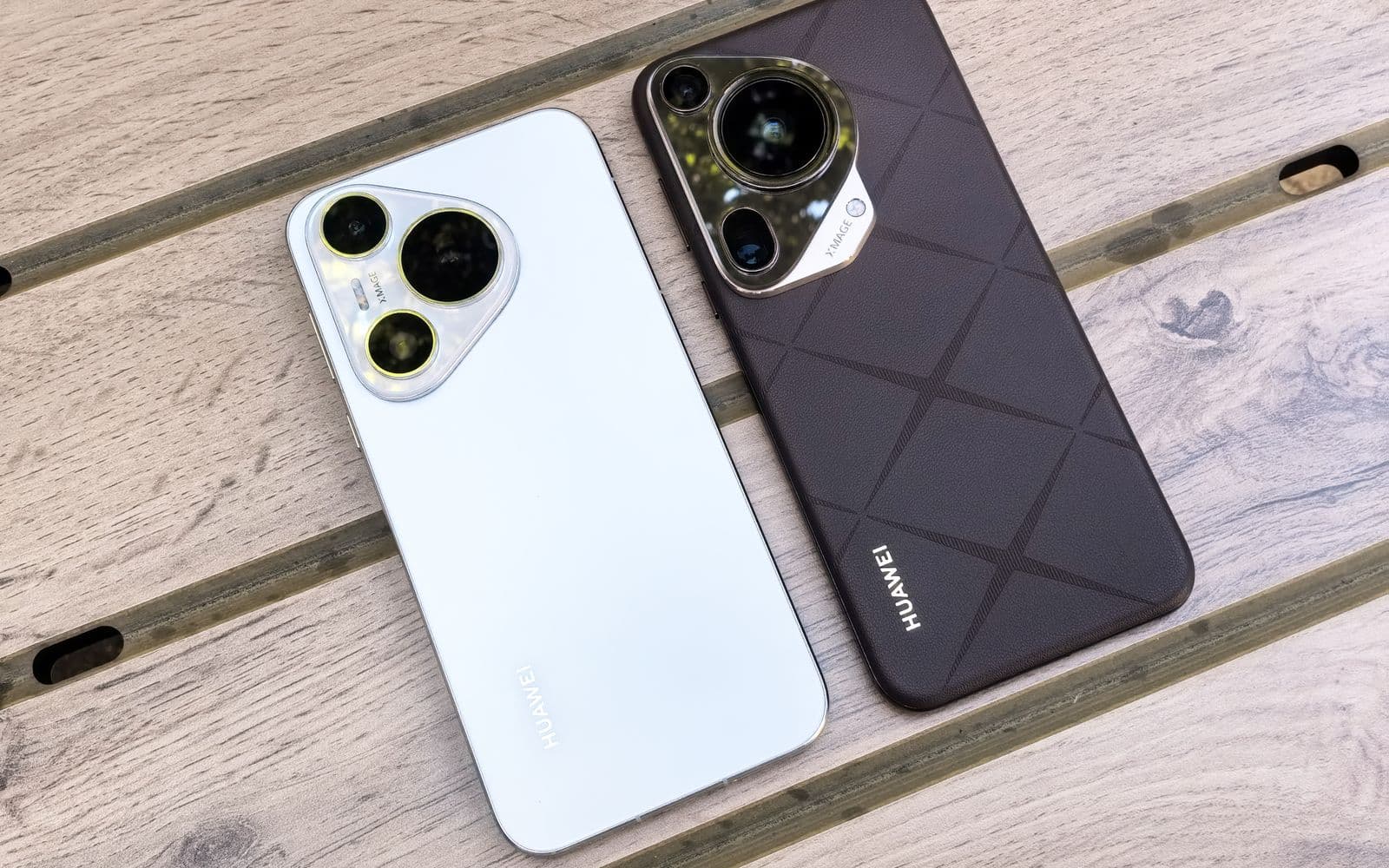 Zwei Smartphones nebeneinander auf einer Holzfläche, die Rückseiten mit den Kameras nach oben