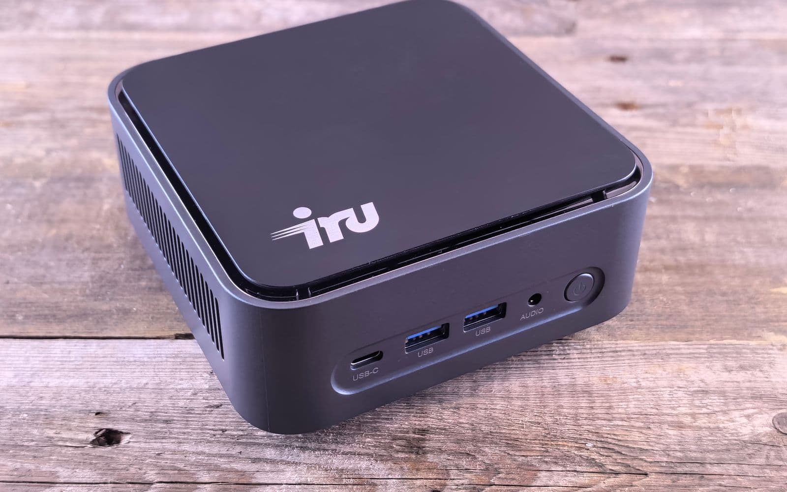 Kleiner Mini-PC mit mehreren Anschlüssen auf einer Holzplatte