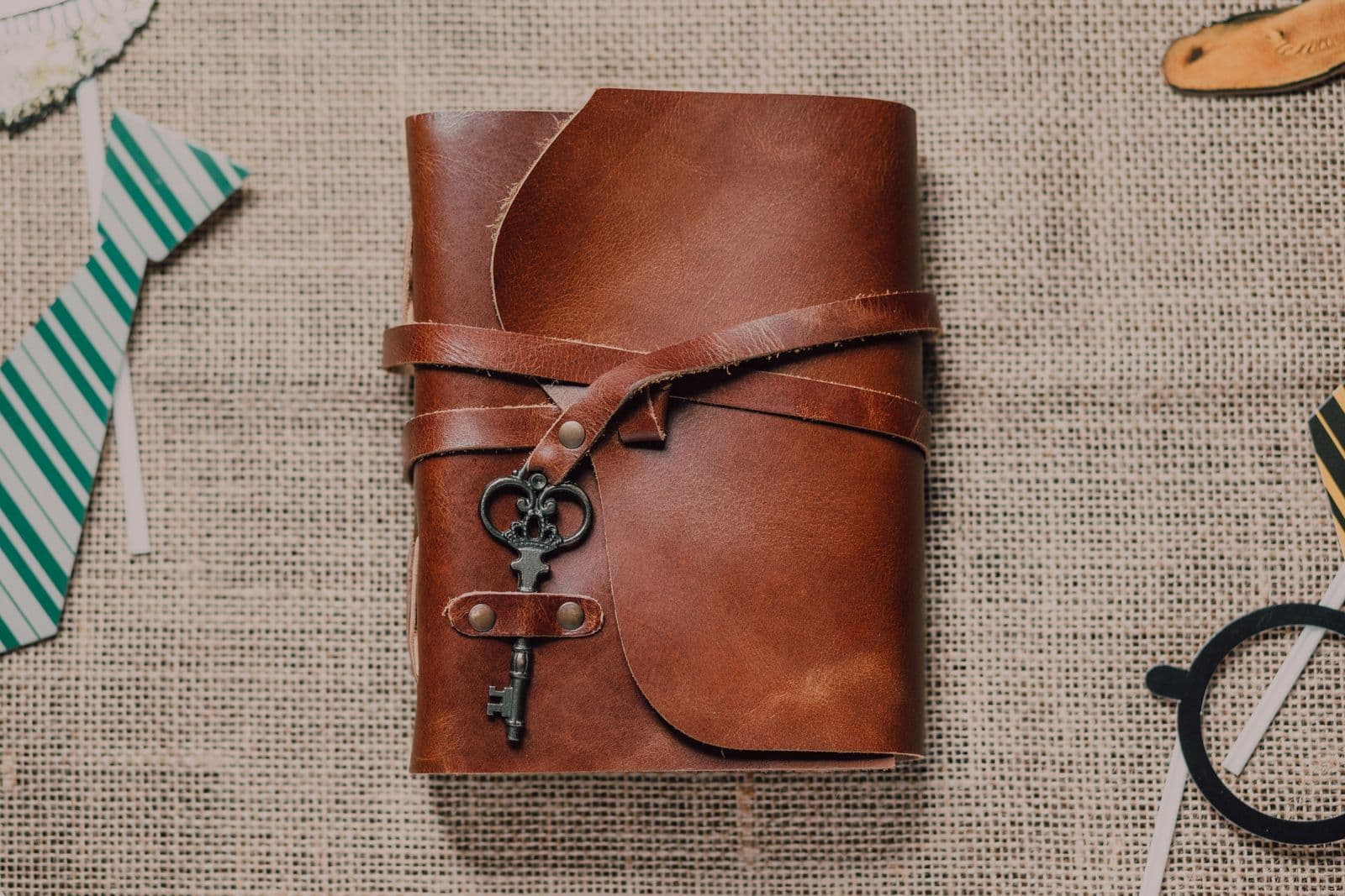 Ein braunes Lederjournal, mit einem Lederriemen verschlossen und mit einem alten Schlüssel als Anhänger