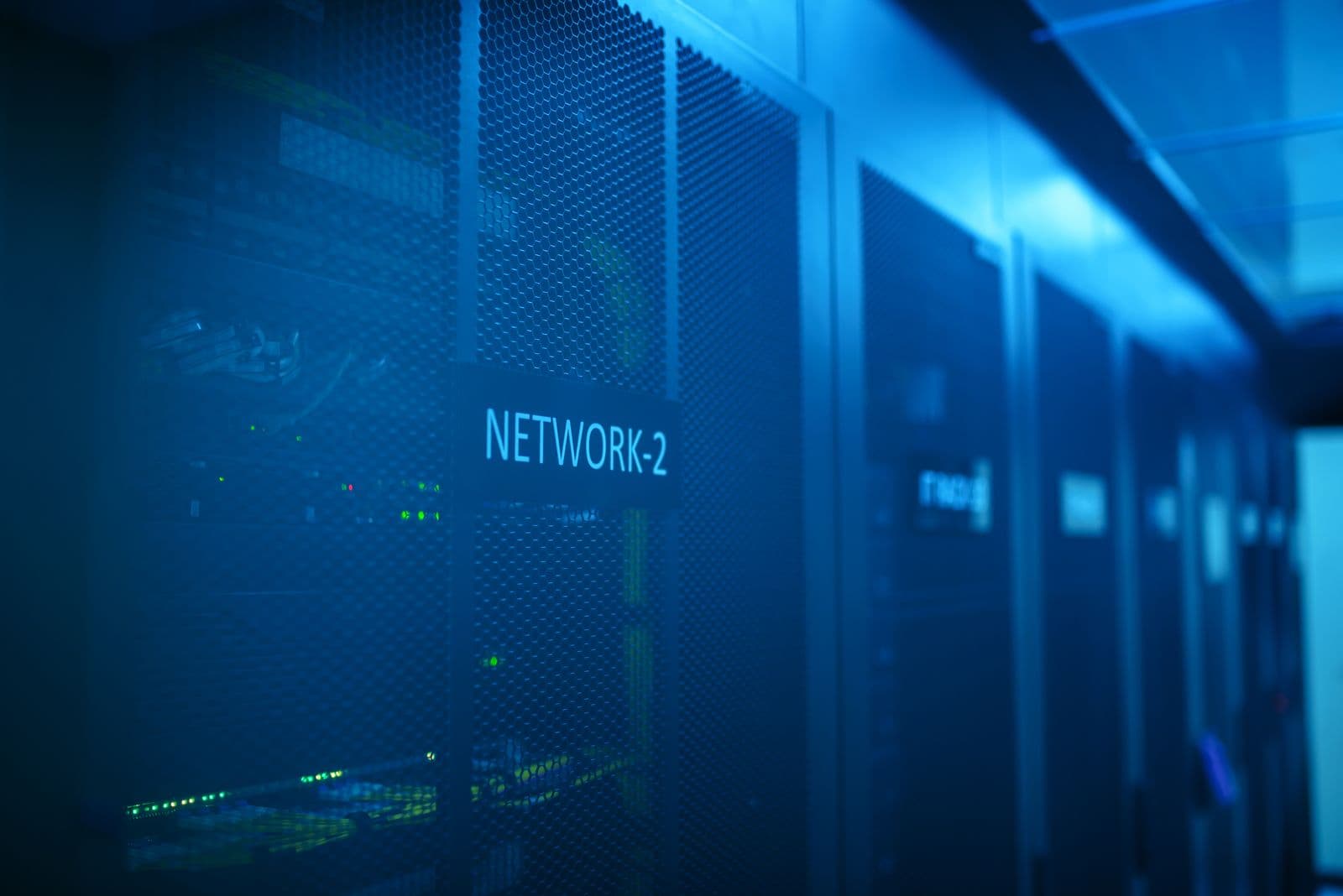 Serverraum-Flur mit blau beleuchteten Rack-Reihen in einem Rechenzentrum