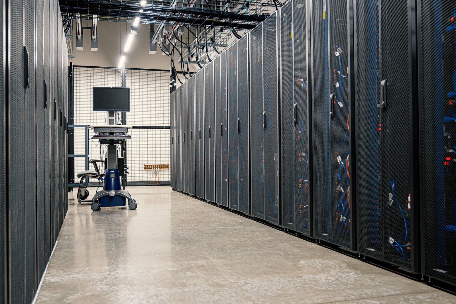 Reihe von Server-Racks mit Stahlrahmen, Netzwerkgeräten und Kabeln in einem modernen Rechenzentrum