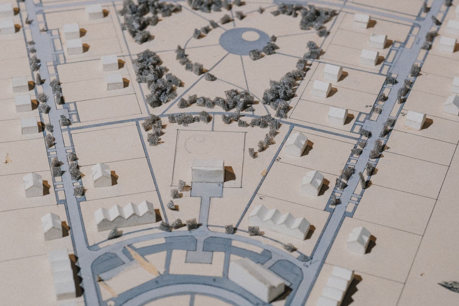 Detailliertes Architekturmodell aus Karton mit Häusern, Straßen und Grünflächen, von oben fotografiert
