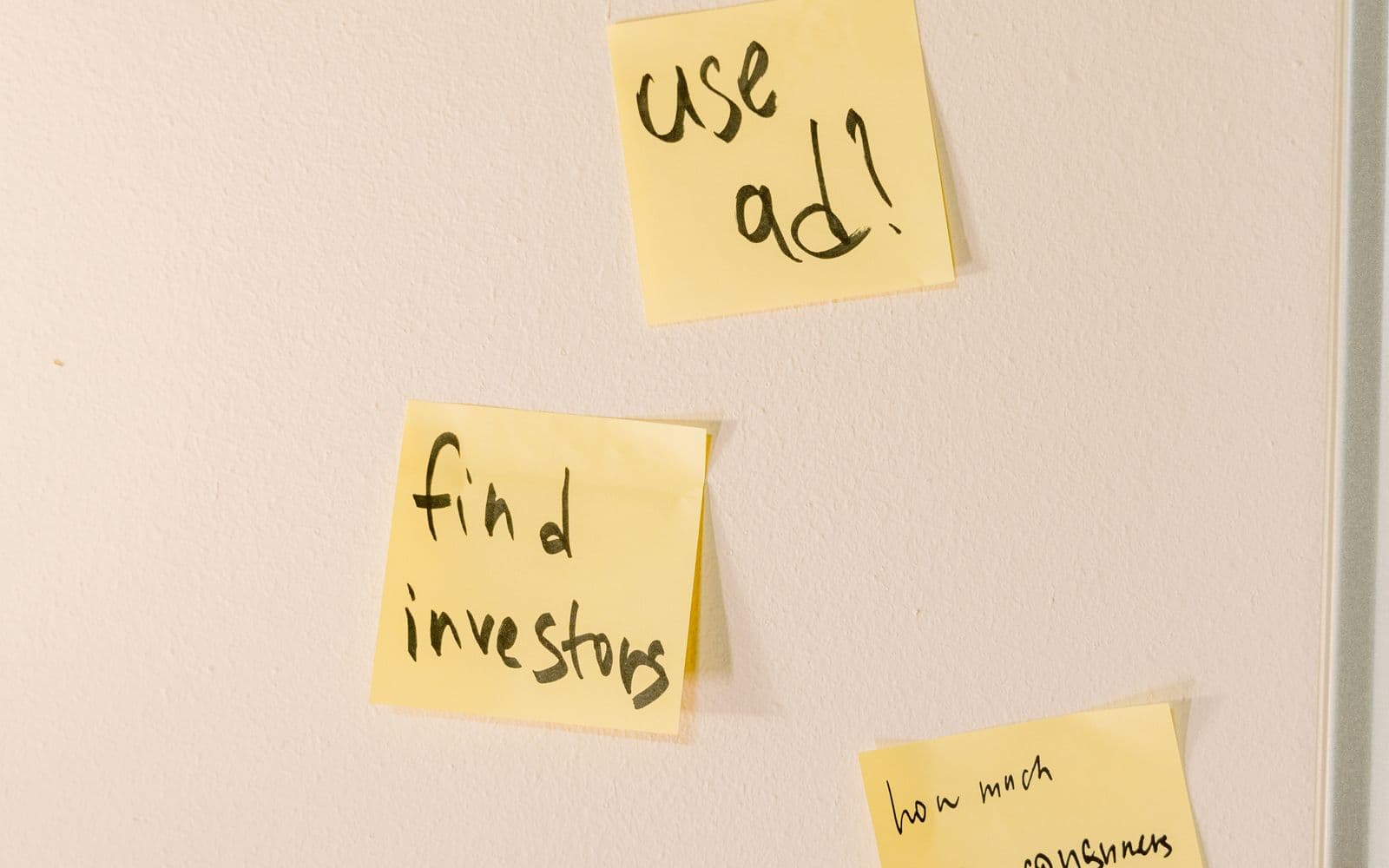 Yellow sticky notes with tasks on a white wall