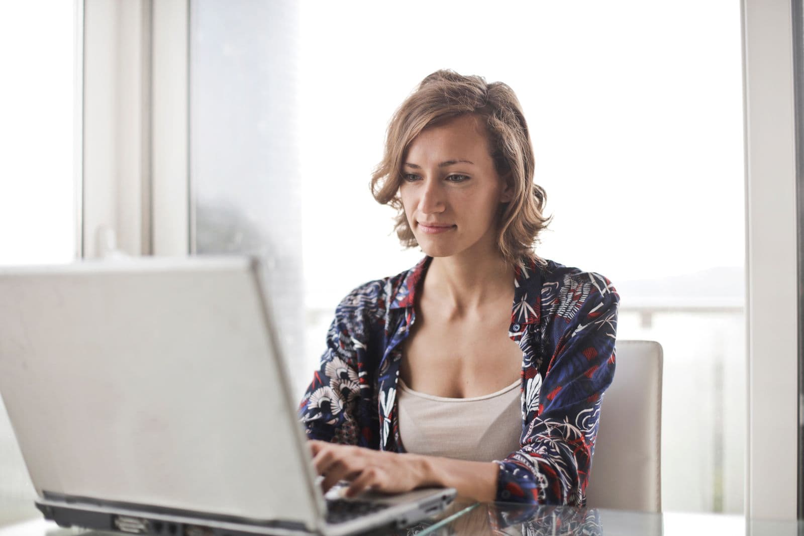 Frau arbeitet konzentriert am Laptop in einem hellen Raum