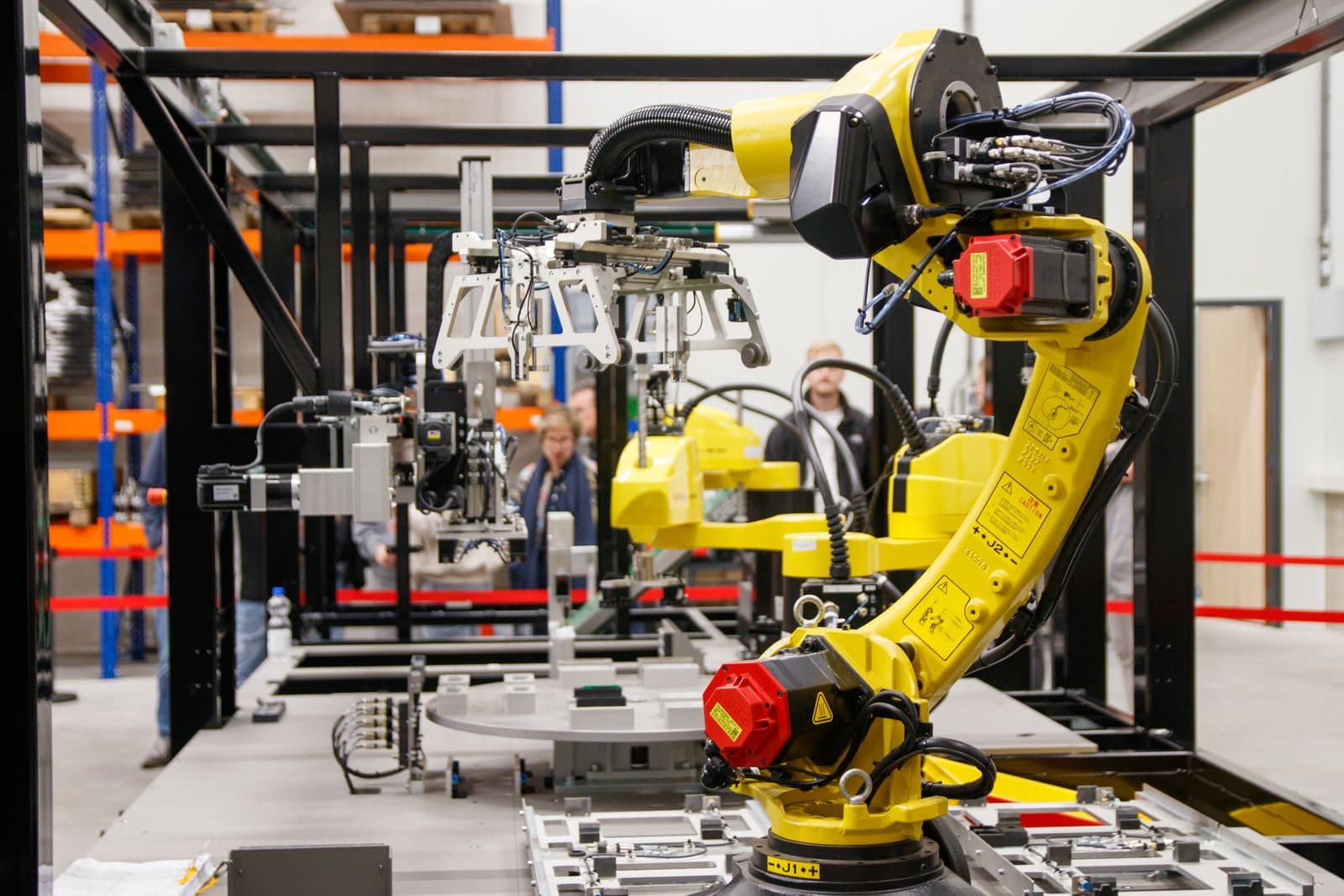 Gelber Industrie-Roboterarm in einer Fertigungshalle